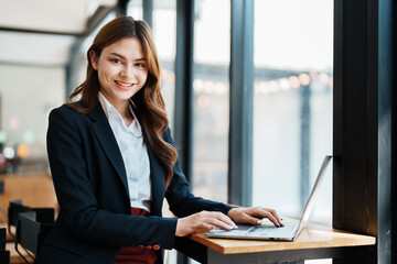 Beautiful young teen asian businesswoman using laptop computer and paperworks with planning working on financial document, tax, exchange, accounting and Financial advisor