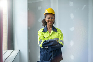 Portrait of black woman engineer cross her arms at chest, looking at camerra with smile of happiness and success.
