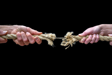 Mann und Frau ziehen an einem reißenden Seil als Symbol für Kampf um Geld oder Sorgerecht