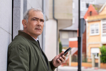 serious adult man on the street with mobile phone