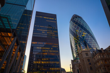 Low angle view of financial district in the City of London at evening, featuring 30 St Mary Axe and St Helen's