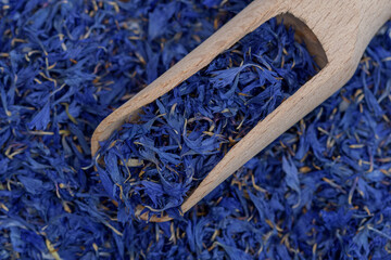 Niebieskie tło z suszonych kwiatów na drewnianej łyżce 