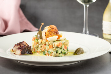 Russian salad with aioli sauce, shrimp, octopus and capers on a white porcelain plate © yalcinsonat