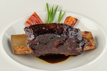 Long cooked marinated beef ribs on a white porcelain plate