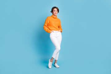 Fototapeta na wymiar Full size photo of pretty young girl posing new autumn collection shopping dressed stylish orange outfit isolated on blue color background
