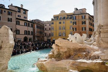 Fototapeta na wymiar Numerous tourists marvel at the Trevi Fountain in Rome, Italy.