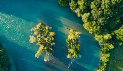 Zauberhafte Flussinseln strahlen mit dem klarblauen Wasser um die Wette. Satt grüne Bäume im Frühlingslaub.