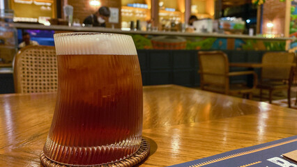 Iced tea with a unique glass shape is served on a restaurant table