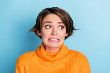 Photo of terrified anxious girl grinning teeth look empty space isolated on blue color background - obrazy, fototapety, plakaty