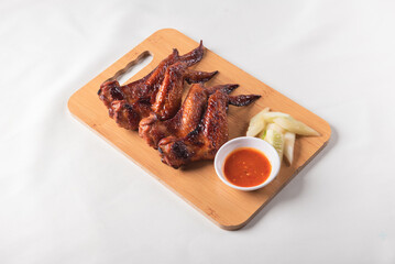 grilled bbq roasted golden honey chicken wing with spicy chilli sauce and onion on wood table asian chinese halal meat banquet snack menu for restaurant and stall