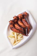 grilled bbq roasted golden honey chicken wing with spicy chilli sauce and onion on wood table asian chinese halal meat banquet snack menu for restaurant and stall