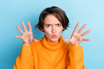 Photo portrait of attractive young woman raise hands frighten boo funky fooling wear trendy orange...