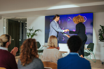 Host welcoming speaker at business convention.