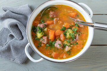 Carrot stew with potatoes and smoked pork meat in a pot