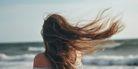 Naklejka premium Beautiful woman enjoying wind at beach. Woman relaxing at beach enjoying summer holiday