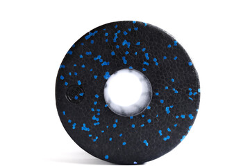 A black blue massage foam roller isolated on a white background. Close-up. Foam rolling is a self myofascial release technique. Concept of fitness equipment.