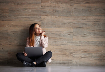 Happy woman, thinking and laptop with space for idea for advertising or mockup. Smile of female on wooden background for internet connection for computer search, promotion or student scholarship