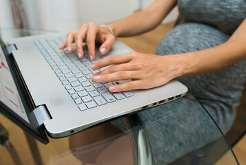 Fototapeta na wymiar Pregnant woman working on her computer at home