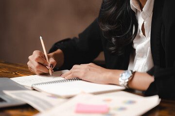 Asian businesswoman reviewing document reports and Signing Contract at office workplace with...