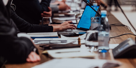 Close up photo of a woman's hand using on a laptop at a seminar