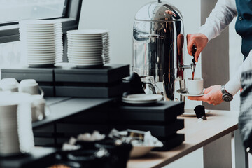 The waiter preparing coffee for hotel guests. Close up photo of service in modern hotels