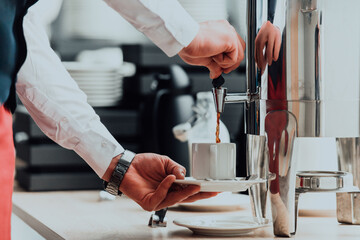 The waiter preparing coffee for hotel guests. Close up photo of service in modern hotels