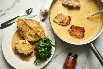 Pork paprikash with onion, butter and garlic. Sauce made from high fat sour cream with chicken stock, flour and paprika