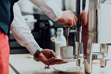 The waiter preparing coffee for hotel guests. Close up photo of service in modern hotels