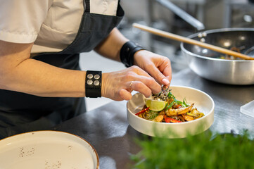 Chef cooking Stir fry noodles with vegetables and shrimps on restaurant kitchen