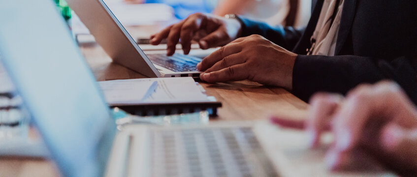 Close up photo of a woman's hand using on a laptop at a seminar