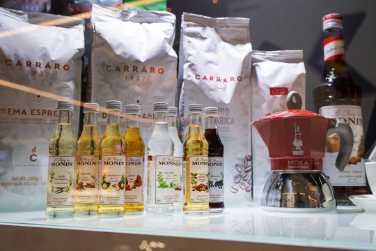 Showcase of a coffee shop with selective focus on the row of syrups bottles Monin. Monin is, a French company, one of the largest syrup producers in the world. Minsk, Belarus, 2023