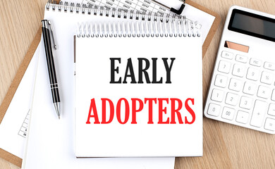 EARLY ADOPTERS is written in white notepad near a calculator, clipboard and pen. Business concept