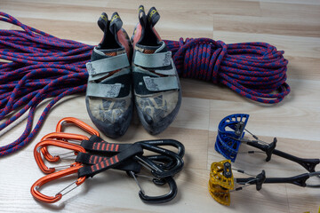 climbing shoes, a coil of rope, two cams and some quickdraws