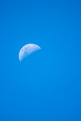 Half moon against clear blur sky during late noon - Singapore