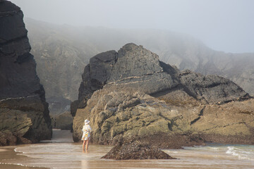 Female Figure with Sea, Cliffs and Rocks With Mist at Odeceixe Beach; Algarve; Portugal