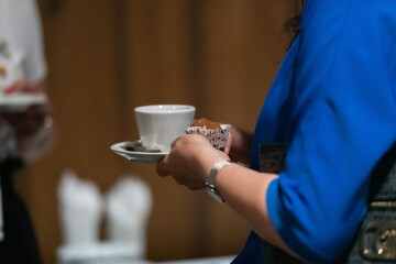 Close-up photo of a business woman holding a cup of fresh coffee