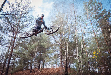 Fototapeta na wymiar Mountain biker jumping in the forest