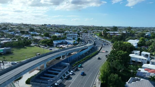 Drone shot of heavy traffic on Lutwyche and Gympie Road, Kedron, Brisbane. Camera tracking towards standstill traffic. Shot in afternoon light with blue skies.