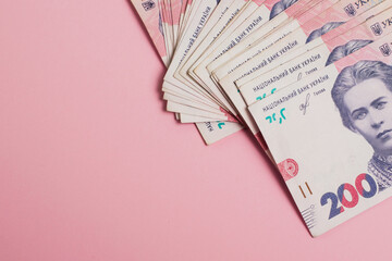 Money, Ukrainian hryvnia bills on pink paper background with copy space
