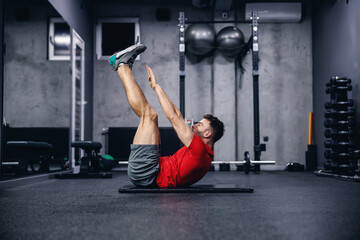 Fototapeta na wymiar Fitness routine and weight loss, sports life. Man correctly performs demanding core exercises on the pathos of the modern gym and sports center concept. Individual training and achieving fitness goals