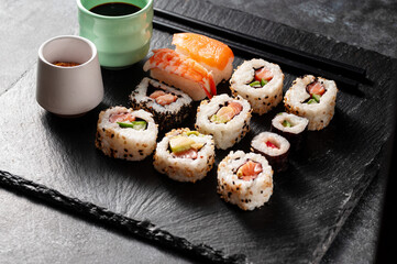 Homemade sushi rolls with salmon, shrimp, avocado. Served with soy sauce and ginger.
