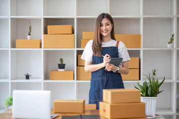 Fototapeta na wymiar Starting Small business entrepreneur SME freelance, Portrait young woman working at home office, BOX, smartphone, laptop, online, marketing, packaging, delivery, b2b, SME, e-commerce concept..