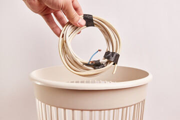 The old electric wire is thrown into the trash. Waste disposal and recycling.