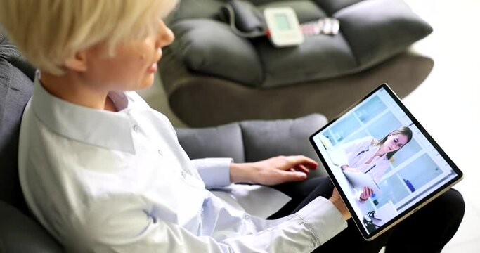 Patient and doctor communicating online via video link using digital tablet. Modern remote medical care via internet concept