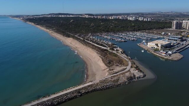 Aerial approaching shot of Segura river mouth with Marina de las Dunas Port, in Guardamar del Segura, Spain