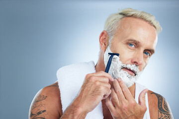 Senior man, razor and shaving beard with cream for skincare grooming or hair removal against studio...