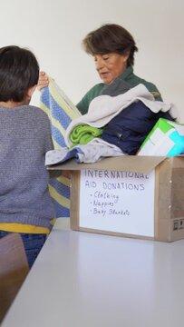 Grandmother and grandchild collecting blankets for international aid on a natural disaster