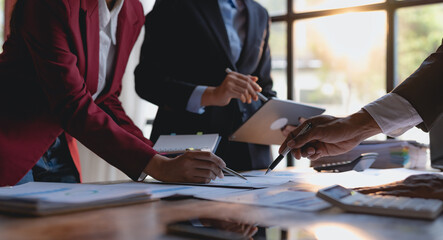 Group of businesspeople meeting together analyzing and pointing graph about business growth.