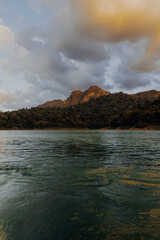 Traditional wooden long tail boat cruise on Cheow Lan Lake among rock formations in Khao Sok National Park, Surat Thani Province in Thailand, Southeast Asia