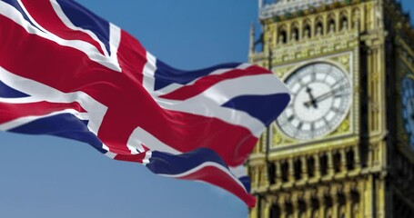 Slow motion loop of UK flag waving with blurred Big Ben on the background